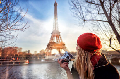 traveling and lifestyle concept.tourist woman with red beret admiring the Eiffel tower and holding camera in her hand.